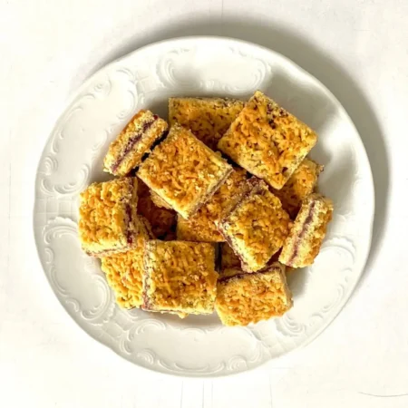 Barritas artesanales cuadradas rellenas de mermelada de mora con cubierta crocante en plato blanco.