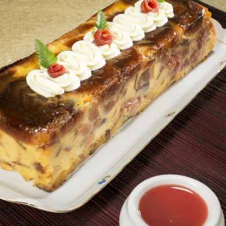 Torta artesanal rectangular de almojábana con bocadillo de guayaba, crema y detalles decorativos.