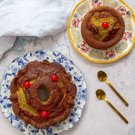 Torta artesanal de limón y semillas de amapola estilo rosca decorada con cerezas.