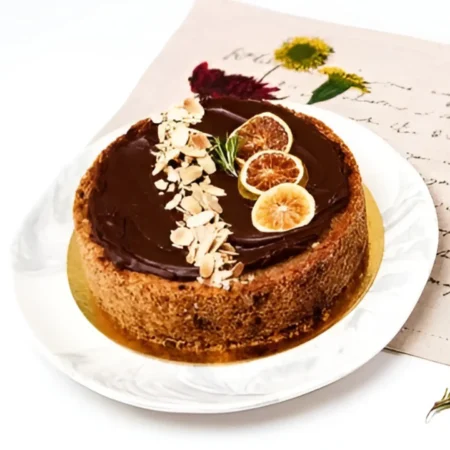 Torta artesanal de naranja cubierta de chocolate oscuro, rodajas de naranja deshidratada y almendras.